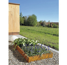 Metalen plantenbak met bloeiende planten en een decoratieve bol in de tuin