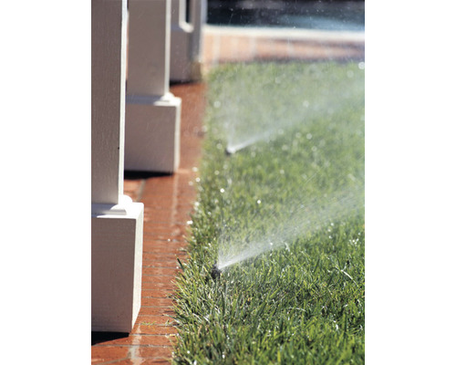 Gazonbesproeiing met gazonsproeier in de tuin