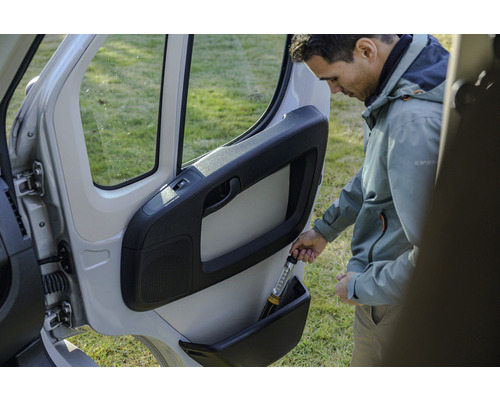 Man bergt zaklamp op in opbergvak autodeur