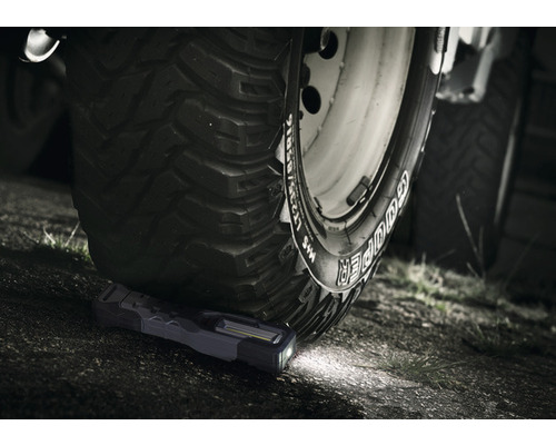 Een LED-werklamp onder een autoband.