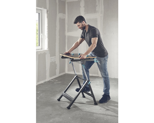 Een man gebruikt een inklapbare werktafel in een kamer.