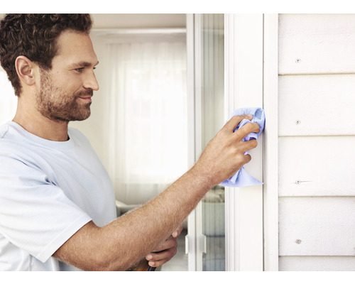 Man reinigt raamkozijn met een doek