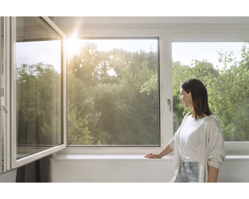 Vrouw bij het raam met uitzicht op groen