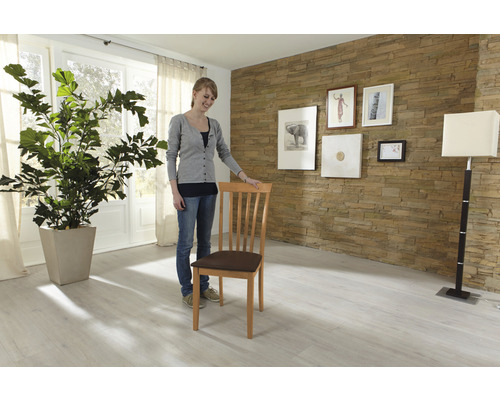 Woonkamer met houten stoel, kamerplant en wanddecoratie