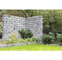 Grijze tuinmuur met beplanting in de tuin