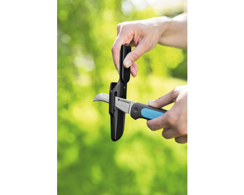 Tuinschaar met bescherming wordt in de beschermhoes gestoken