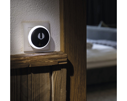 Intelligente regelaar aan de wand naast houten element