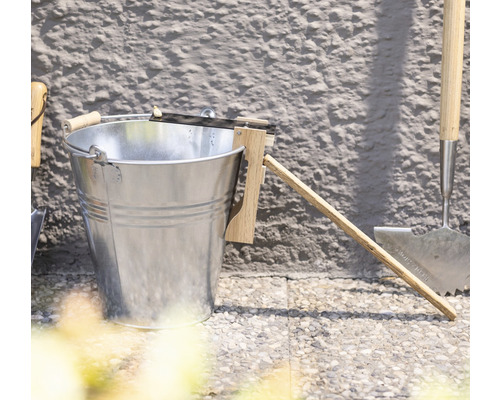 Metalen emmer met afstrijker voor de tuin, samen met tuingereedschap