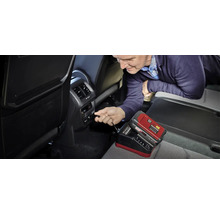 Man sluit een acculader aan in de auto