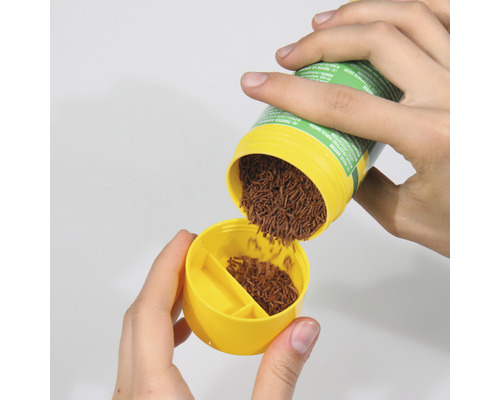 Visvoer wordt in een gele doseerder gegoten