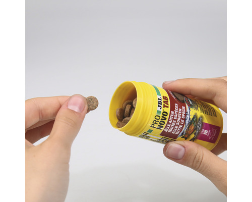 JBL Novo Tab voedertabletten voor alle vissoorten worden uit een gele container gegoten