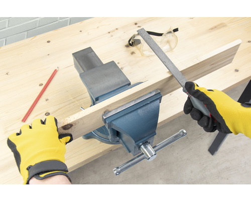 Werkbank met bankschroef, houten plank en vijl voor houtbewerking.