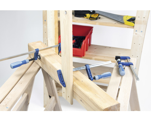 Werkbank met schroefklemmen en gereedschap op planken