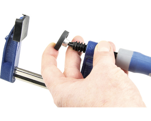 Een bankschroef wordt bediend met een hand.