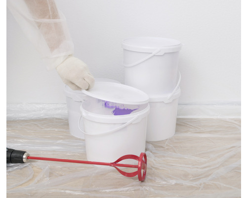 Meerdere witte verfemmers met verfmixer en afdekfolie.