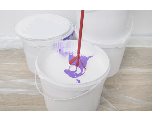 Verfmixer in een verfemmer met verf