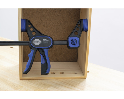 Een INDUSTRIAL snelspanklem fixeert een werkstuk.