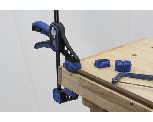 Pijp bevestigen met een pijpklem op een werkbank, samen met een metaalzaag en pijpsteunen