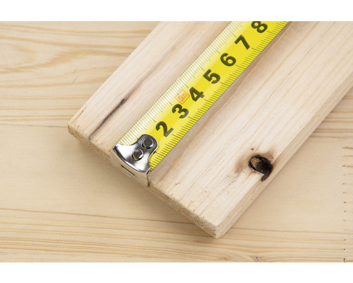 Geel rolmaat op een houten plank