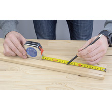 Rolmaat en potlood voor het meten van een houten plank