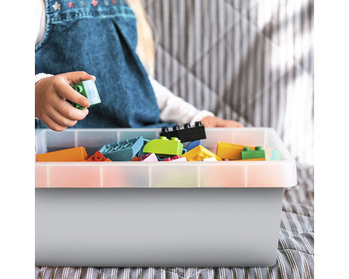 Kind speelt met bouwstenen in een opbergbox