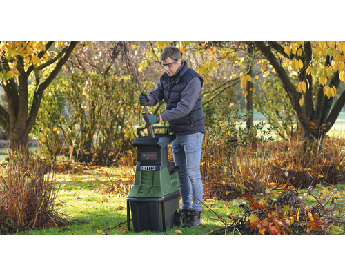 Man gebruikt een Bosch tuinhakselaar in de tuin.