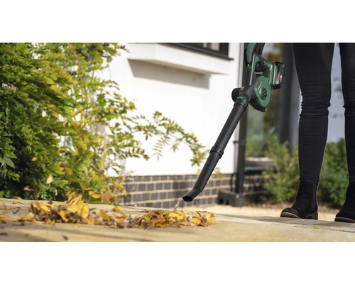 Persoon gebruikt een draadloze bladblazer voor tuinwerkzaamheden.