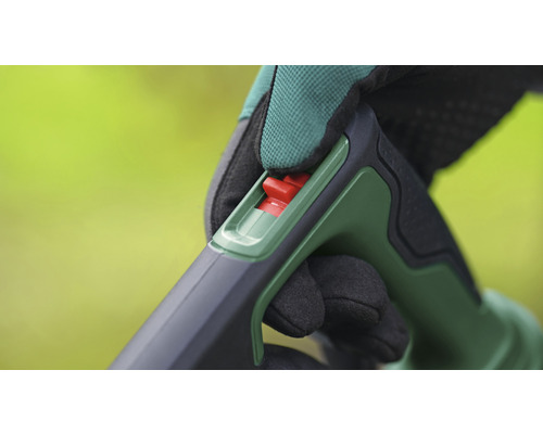 Detailopname van de bediening van een tuingereedschap met rode schakelaar