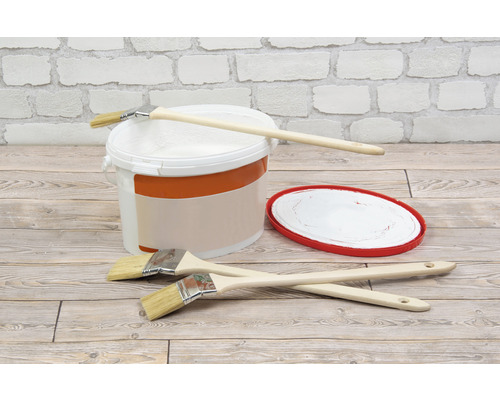 Verfemmer, penselen en verfbak voor een bakstenen muur