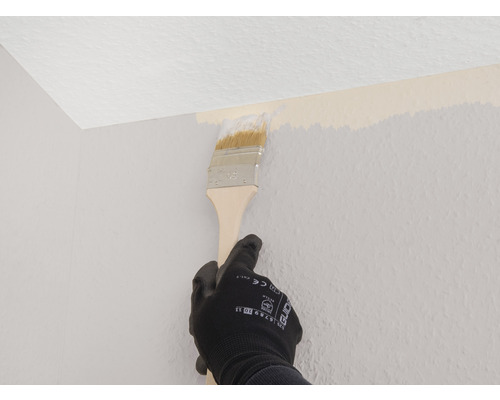 Persoon schildert muur met een verfkwast