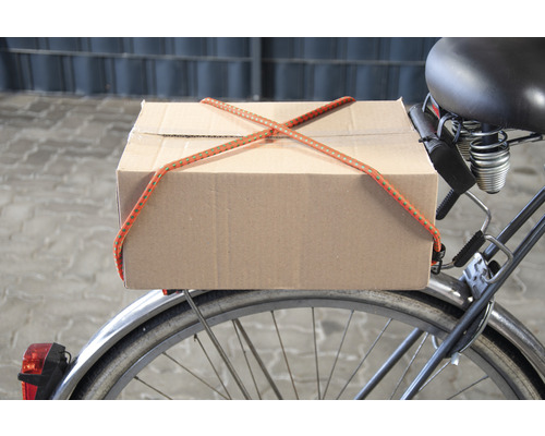 Een doos is met een bagagespin op een fiets bevestigd.