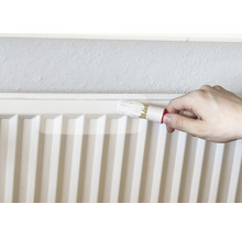 Radiator wordt geschilderd met radiatorborstel