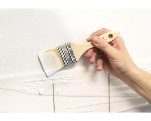 Hand schildert muur met een kwast van 50 mm