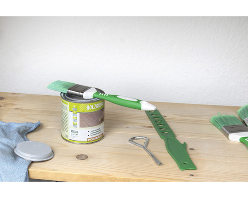 Houtbeits blik met kwast en gereedschap op houten tafel