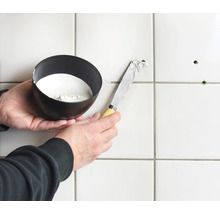 Tegelreparatie met plamuurmes en vulmateriaal