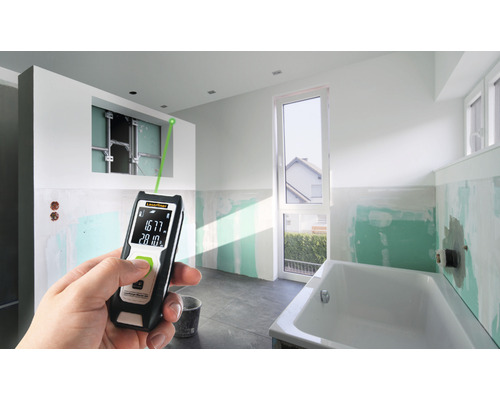 Hand met laser afstandsmeter in een badkamer