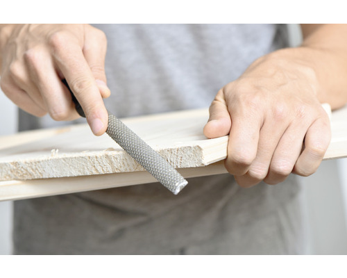 Een houtrasp wordt gebruikt om een stuk hout te bewerken.