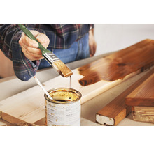 Houtbeschermingsbeits met een kwast aanbrengen op een houten plank