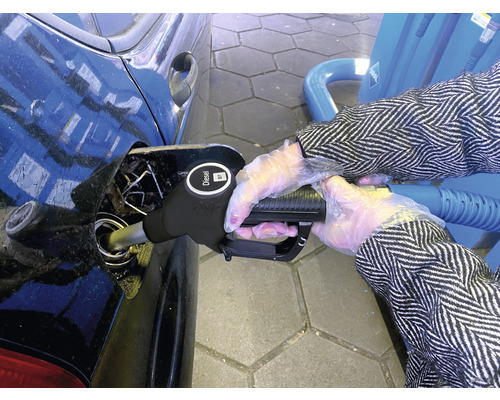 Een persoon tankt een auto met diesel bij een tankstation