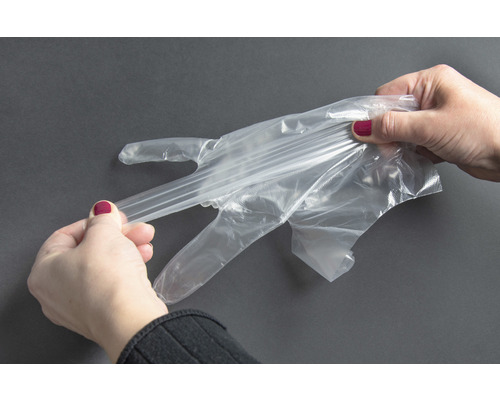 Vrouw trekt transparante wegwerphandschoen aan