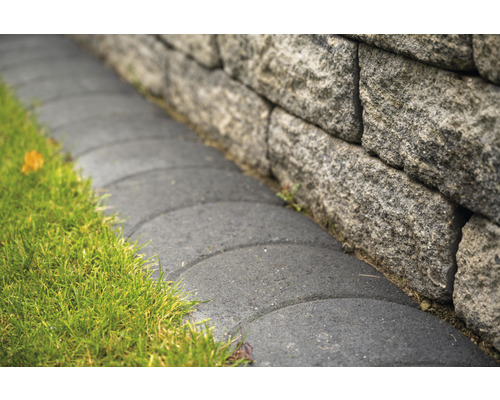 Stenen muur met grasveld en verhard pad