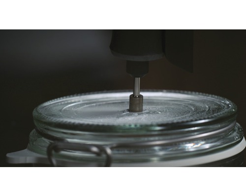 Een glazen pot wordt bewerkt met een roterend gereedschap