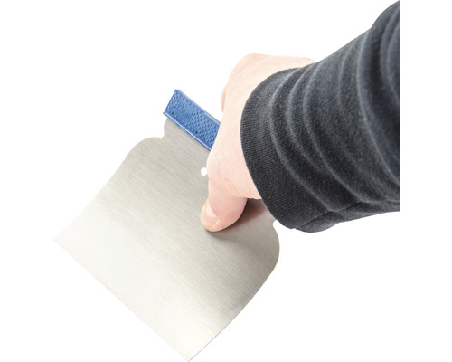 Hand houdt een plamuurmes vast.