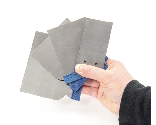 Hand houdt een set van verschillende metalen plamuurmessen vast