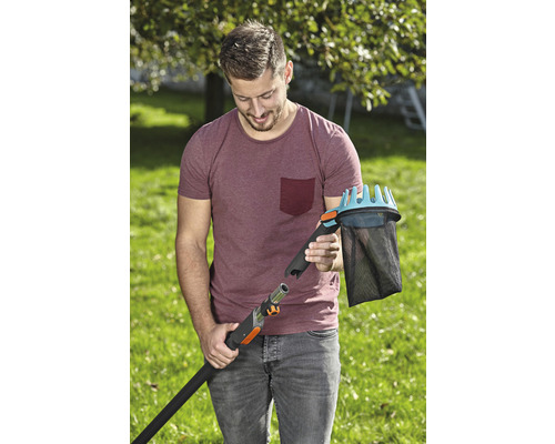 Een man verbindt een fruitplukker met een telescopische steel in de tuin.