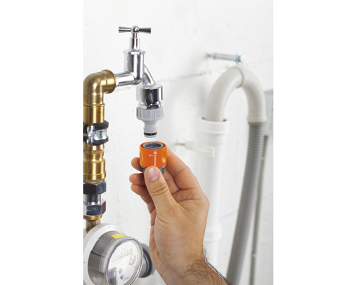 Hand bevestigt Gardena-adapter aan waterkraan voor tuinbewatering