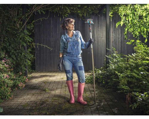 Vrouw in de tuin met een hark en tuingereedschap