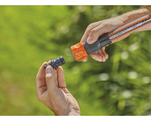 Persoon verbindt tuinslangstuk met tuinslang