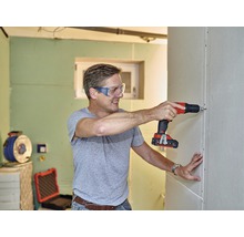 Man schroeft gipsplaatwand met accuschroefboormachine