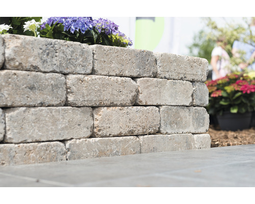 Muur van betonblokken met bloemenbeplanting